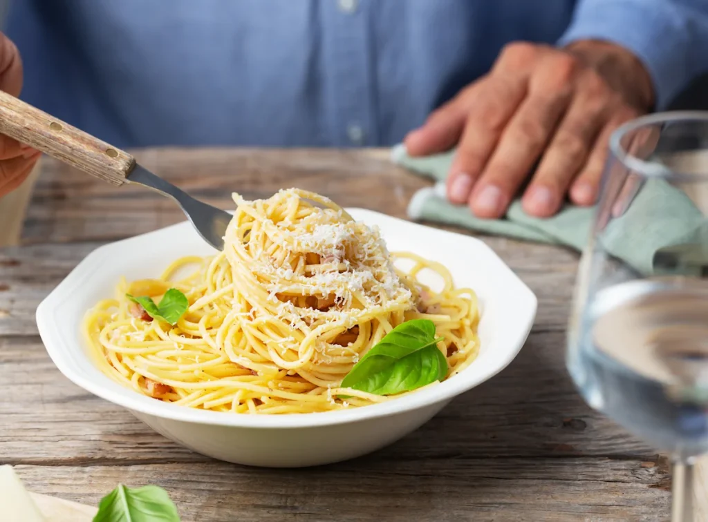 Un homme qui mange une assiette de pâtes italiennes