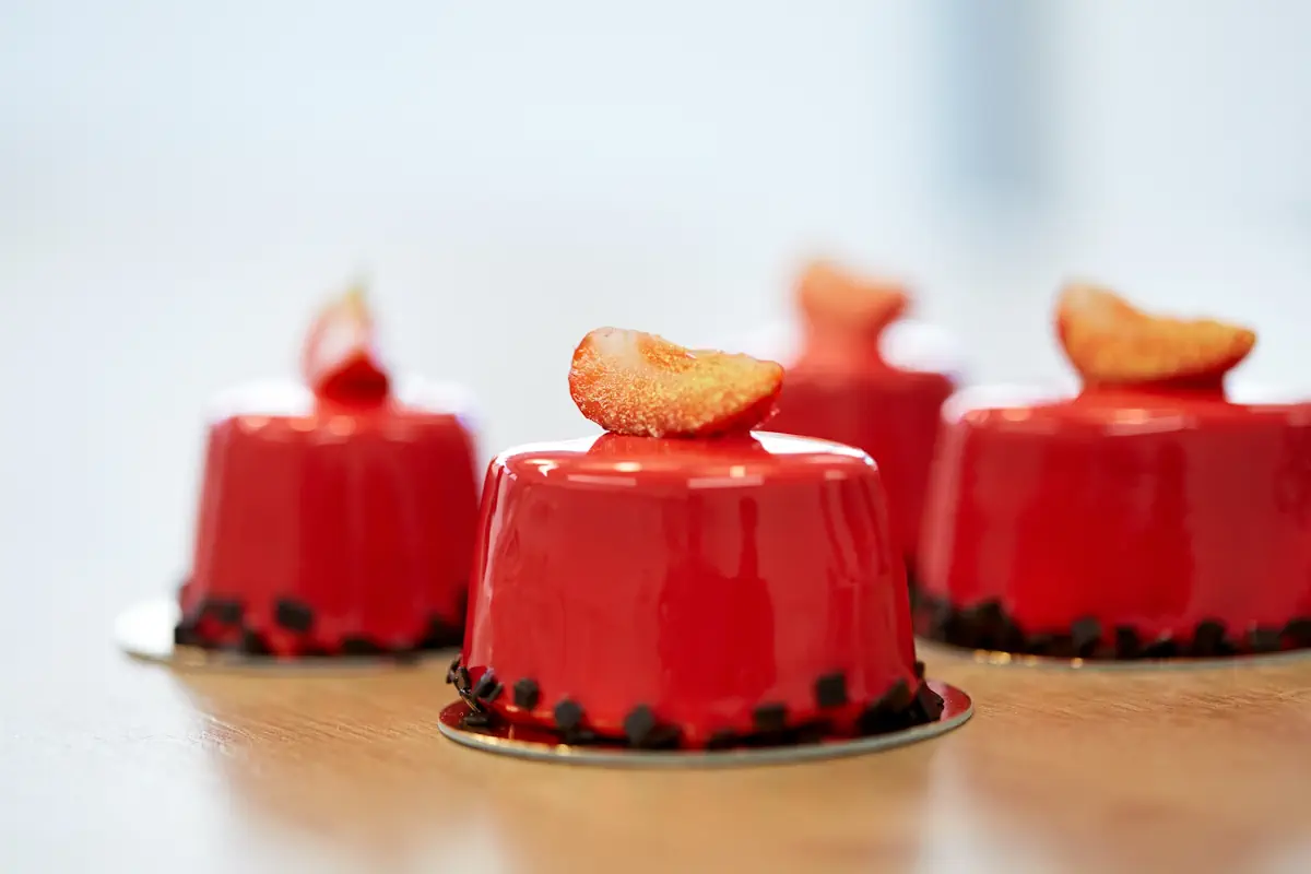 Des pâtisseries rouges posées sur la table