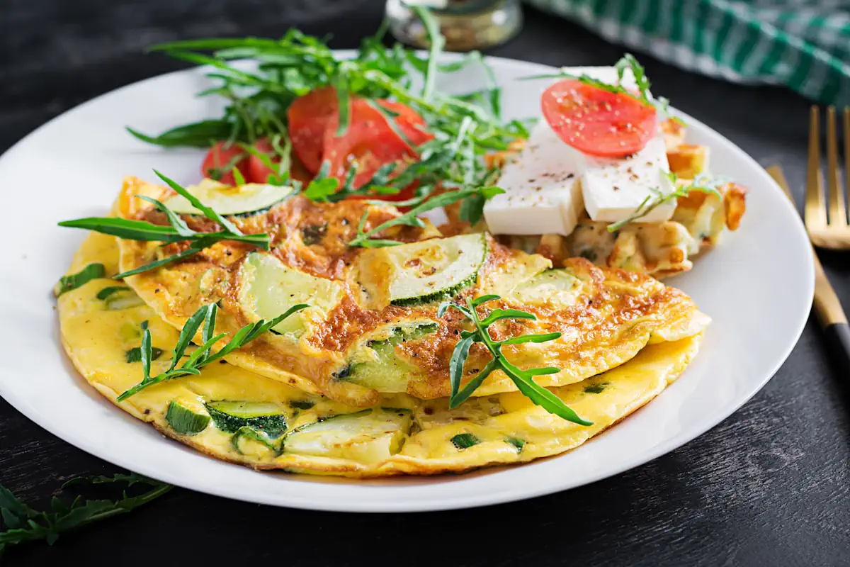 Une assiette d'omelettes aux courgettes avec des légumes et du fromage